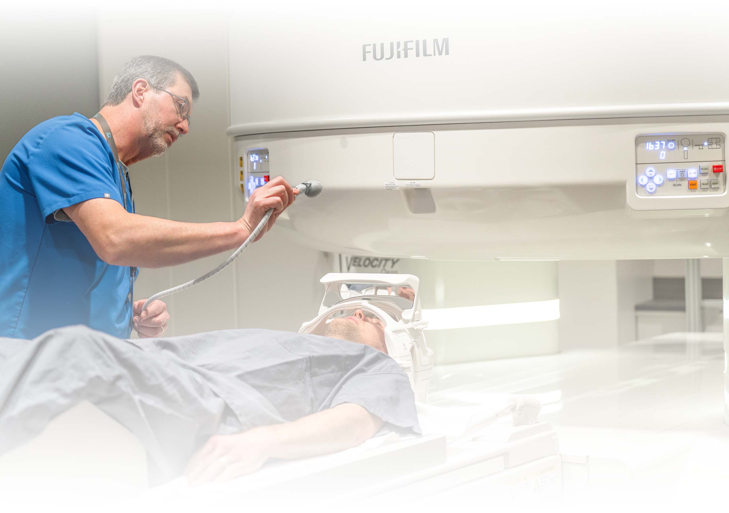 A technical prepares a patient for an open field MRI
