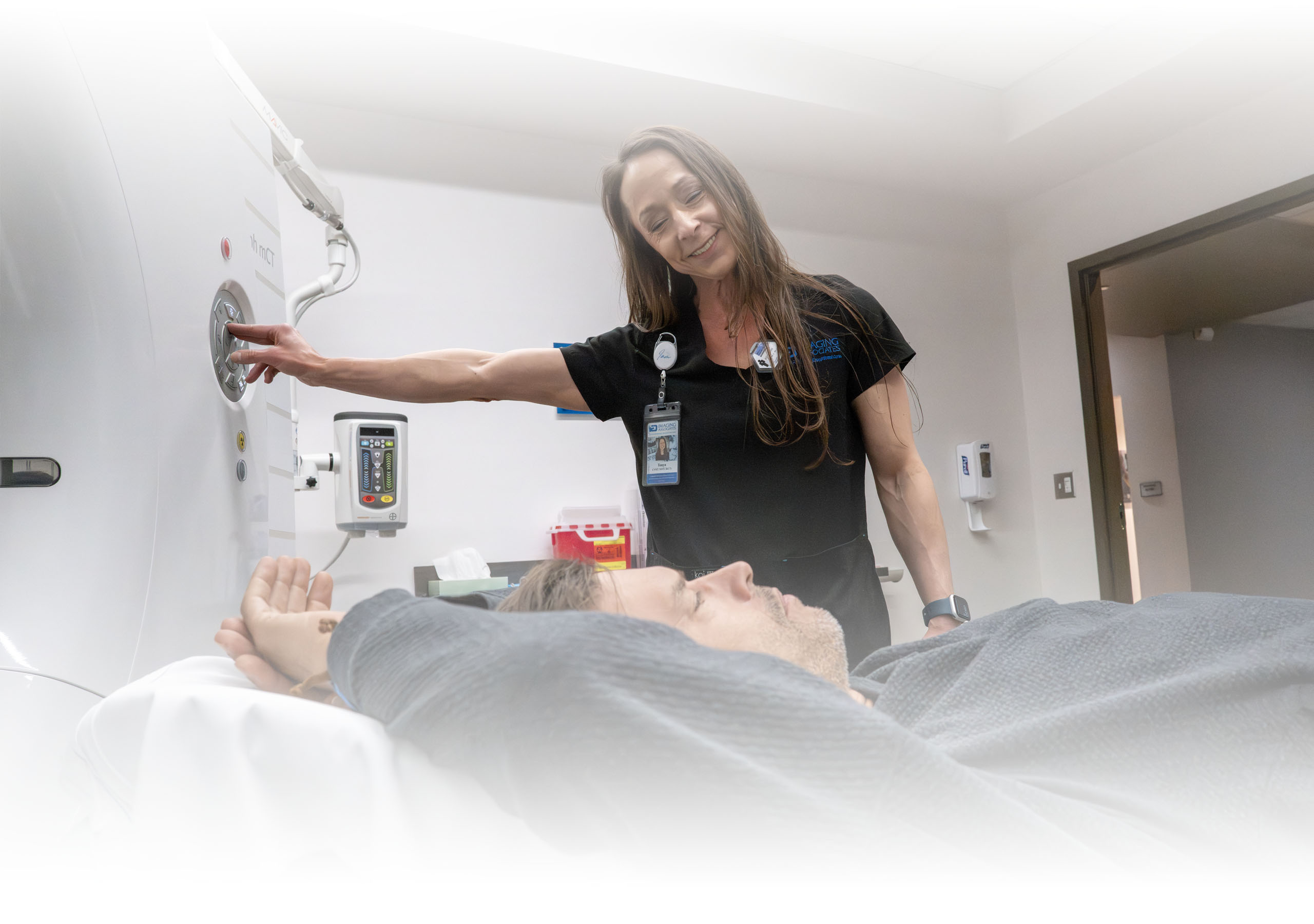 A technician working with a patient during a PET/CT scan